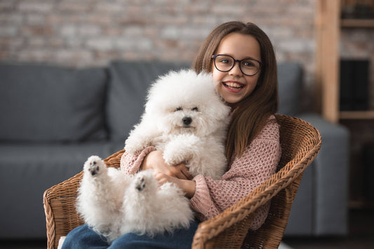 Kid with a puppy sat on her knee